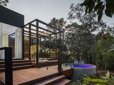 The rear of the house is harmonised with the crisp black Axon cladding and a pergola acts as an architectural series of portals