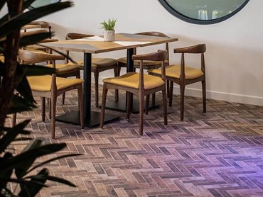 The tactile materiality of the rustic clay bricks is evident on the function room floor