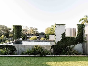 The garden includes two outdoor showers enveloped in creeping ficus, and a concrete outdoor bath