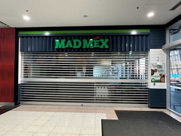 The very wide shopfront opening features a single electric-operated roller shutter 