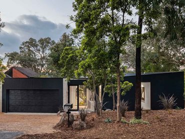 The home nods toward traditional Japanese architectural concepts of charred black classed log cabins