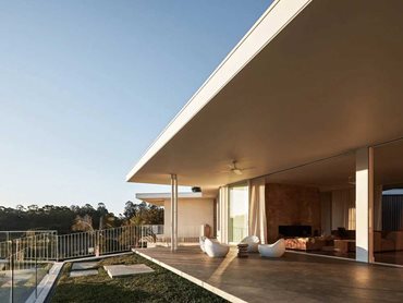 The home is a crisp linear pavilion that seamlessly integrates into the surrounding rural landscape