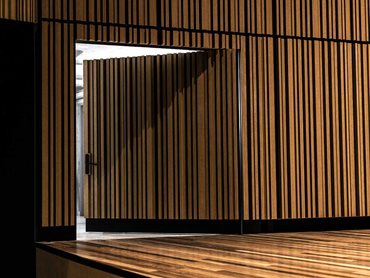 A custom SUPASLAT slatted wall system ran around the stage walls and stage doors