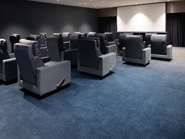 A gradient deep toned carpet and twinkling ceiling lighting provide the mood in the cinema