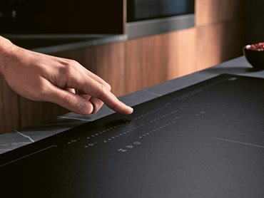 The sleek matte black glass induction cooktop combines revolutionary technology and design 