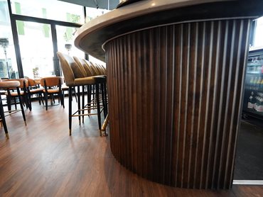 The curved timber wraps elegantly around bar ends