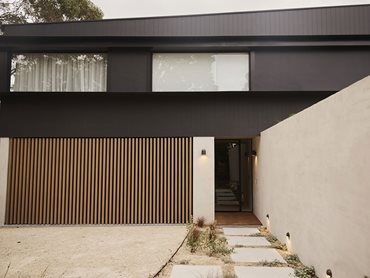 The battens give the illusion of natural timber, seamlessly connecting the dark top of the home with the lighter bottom half