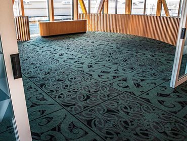 The carpet incorporates Māori carving and painting art forms, reflecting traditional Kowhaiwhai motifs