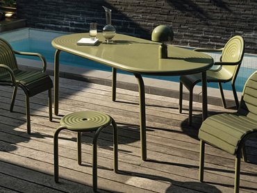 Featuring Art Deco-inspired ridges, the collection includes an oblong table, chairs, armchairs, and stools